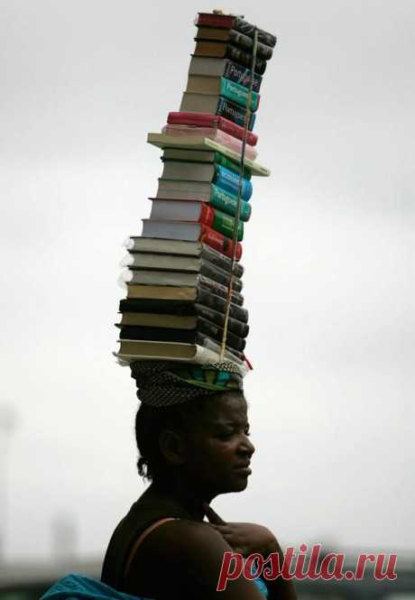 Женщина несет книги для продажи в Луанде, Ангола. Facebook