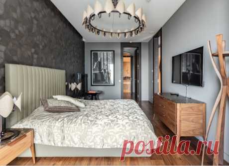 Спальня в современном стиле с серыми стенами, темным паркетным полом. Мебель поддерживает коричневый цвет в пространстве.