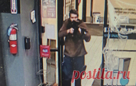 Полиция США опубликовала фото подозреваемого в стрельбе в Льюистоне. На снимке изображен светлокожий мужчина средних лет в коричневой толстовке со штурмовой винтовкой в руках