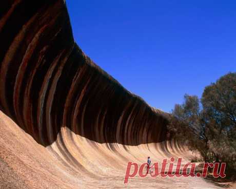 Каменная волна (Wave Rock) – удивительное по красоте скальное образование в Западной Австралии, которое напоминает собой гребень исполинской волны, как будто кто-то превратил воду в камень. Видимая часть скалы возвышается над землей на высоту около 15 метров, а ее протяженность – 110 метров.