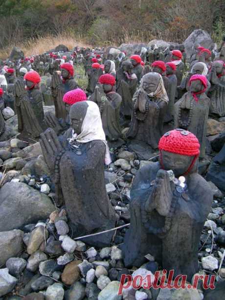 Статуи Jizo (дзизо) в вязаных шапках у подножия вулкана в Японии (7 фото)
