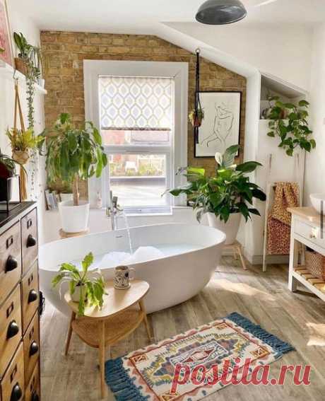Уютная ванная комната с ванной в центре и цветами