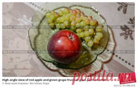 High angle view of red apple and green grape fruits in glass plate on table Стоковое фото, фотограф Анастасия Усанина / Фотобанк Лори