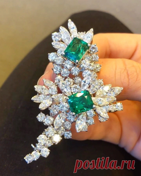 This beautiful brooch of floral design is encrusted with bright Colombian emeralds together with marquise and round shaped diamonds.