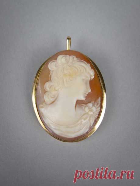 Vintage 18 Carat Gold Finely Carved Cameo Brooch / Pendant. A lovely vintage cameo in an 18 carat gold setting with both a brooch pin and a pendant loop.  The cameo is finely carved and depicts a lady's head and shoulders with foliate detail to the top of the dress. The gold setting is of a simple design with an extremely fine rope twist rim. '750' is stamped to the rear of the