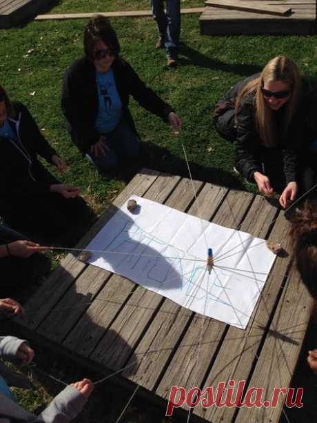 Marker is attached to 8 strings, and the group has to write out a word by working together and only holding onto the last foot foot of each string.