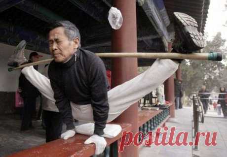 Пожилой Китаец тренирует растяжку в храме