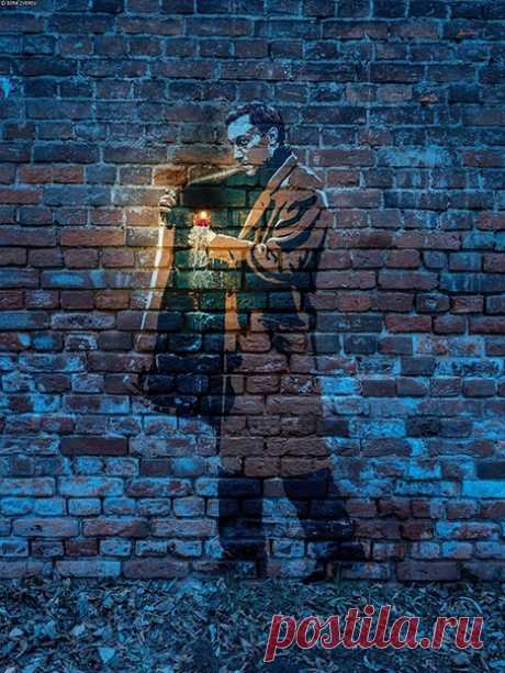 Интерактивное граффити у дoма Тарковского в Москве. Олег Янковский из фильмa А.Тарковского &quot;Ностальгия&quot;, который несёт горящую свечу. Свечa настоящая - в отверстии в кирпичной стене.