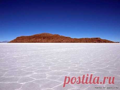 Удивительное соляное озеро Salar de Uyuni располагается в южной части пустынной равнины Альтиплано в Боливии. Когда–то, сорок тысяч лет назад, эта территория была частью доисторического озера Минчин. Со временем озеро пересохло, но после него остались два и ныне существующих озера Уру–Уру и Поопо, а так же два больших солончака, одним из которых и является Салар–де–Уюни.Площадь солончака Уюни составляет 10 582 км2, что делает его самым большим высохшим соленым озером в мире.