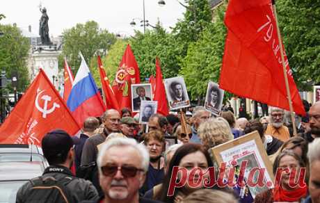 В Париже сотни человек участвуют в акции "Бессмертный полк". Участники мероприятия вместе с красным знаменем Победы несли флаги России, Белоруссии и Франции