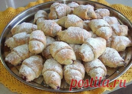 РОГАЛИКИ С ВИШНЯМИ Ингредиенты: На 90-100 штук: Тесто: 500 г муки. 400 г маргарина со вкусом сливочного масла* 4 ст.л. сметаны. 2 желтка. 1/2 ч.л. соли. 1/2 ст. молока. 70 г свежих дрожжей. 1 ст.л. сахара. Начинка: вишни консервированные* Для посыпки: сахарная пудра с ванилью. Начинка: Сцедить с вишен сироп. Тесто дрожжевое слоеное быстрого приготовления: 500 г муки. 400 г маргарина со вкусом сливочного масла* 4 ст.л. сметаны. 2 желтка. 1/2 ч.л. соли....