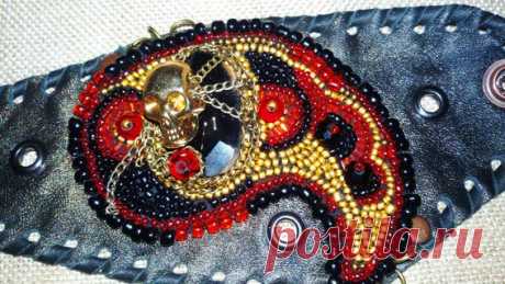 А вот это уже немного интереснее: Весёлый Роджер повис на пьедестале из чёрного агата, на фоне мягкой натуральной кожи в окружении бисера и хрусталя!