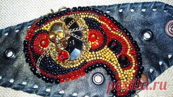 А вот это уже немного интереснее: Весёлый Роджер повис на пьедестале из чёрного агата, на фоне мягкой натуральной кожи в окружении бисера и хрусталя!