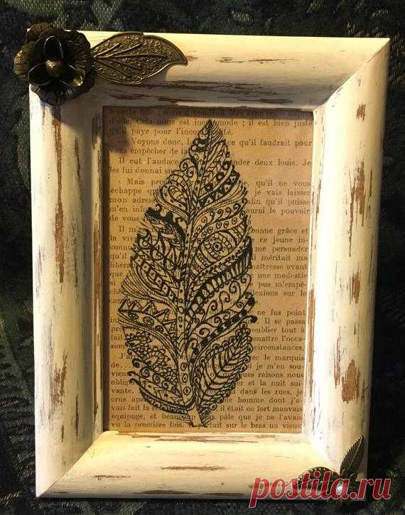 Hand drawn feather on book page. Shabby chic frame. A zentangled feather, hand drawn in black ink on a page from an old French novel. The frame has been painted and distressed in a shabby chic style and decorated with pieces of recycled jewellery.